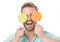 Man holds big lollipops on eyes as eyeglasses. Sweet tooth concept. Guy on smiling face holds two giant colorful