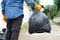 man holds black plastic bag that contains garbage inside.Daily chores. Throw away rubbish.