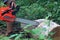 A man holds a chainsaw in his hands and cuts firewood