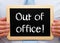 Man holds chalkboard sign Out of Office