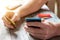 A man holds a credit card in his hands and uses a mobile phone close-up, paying for purchases in online stores, internet banking