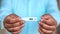 Man holds digital thermometer with temperature reading in Fahrenheit closeup