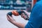 A man holds an electric drill in his hand for drilling. A buyer in a hardware store selects a product