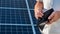 A man holds an empty purse against the background of solar panels. Payment crisis