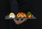 Man holds fresh, tasty shrimp on a stone black tray