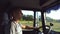 Man holds hand on the steering wheel and driving truck through countryside. Truck driver profile. Trucker sitting at the