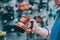 A man holds in his hand a grinding machine on wood. A buyer in a hardware store selects a product