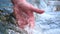 A man holds his hand washes his hands in the fountain water, clearing them of dirt, and holding the water of the waterfall in