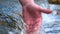 A man holds his hand washes his hands in the fountain water, clearing them of dirt, and holding the water of the waterfall in