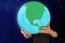 Man holds in his strong hands the globe on a blue cosmic background, the concept of globalization, environmental protection,