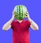 A man holds at the level of the head of a ripe tasty watermelon. Watermelon instead of the head. Advertising of watermelons