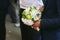 Man holds an original wedding bouquet made of white flowers and