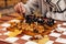 A man holds a pawn in his hand and plays chess in an autumn park on a special site