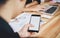 The man holds the phone on a wooden desk in the office. The members are currently meeting. Technological concepts make progress.