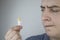 A man holds a rectal candle in his hand. A drug that is inserted into the rectum. Rectal suppository for hemorrhoids, constipation