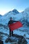 Man holds red flag with copy space for your decoration in front of blurred Everest mountain