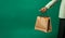 Man holds shopping bag against green background