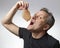 A man holds a slice of Parma ham, Italy in his hand near his mouth as he is about to eat it voraciously