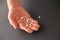 Man holds small white beans on dark background