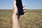 a man holds a smartphone in his hand against the background of a modern wind farm . Mobile phone communication. Modern