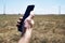 a man holds a smartphone in his hand against the background of a modern wind farm . Mobile phone communication. Modern