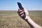 A man holds a smartphone in his hand against the background of a modern wind farm . Mobile phone communication. Modern