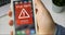 Man holds smartphone with virus alert warning sign on the display