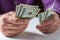 A man holds stack hundred-dollar bills in his hands close-up