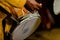 Man holds a stick with his hands to play the traditional dhol drum