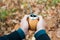 A man holds a traditional drink yerba mate in his hands. Outdoors in the autumn forest. Close-up