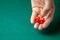 Man holds two red dices and throws them on green poker gaming table in casino. Concept of online gambling, winner or player