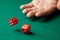 Man holds two red dices and throws them on green poker gaming table in casino. Concept of online gambling, winner or player