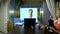 A man holds a video conference at home in the kitchen his wife eats at the table