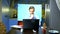 A man holds a video conference at home in the kitchen his wife eats at the table