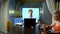 A man holds a video conference at home in the kitchen his wife eats at the table