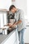 Man in home clothes, slicing bread for sandwiches