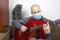 Man in at home in quarantine because of an epidemic of coronavirus plays a classical guitar next to a gray cat