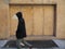 Man with hood walking by double doors