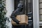 Man with hoodie stealing a package at the doorstep - AI Generated