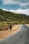 Man on horse riding on Street in steppe with Tian Shan mountains in background, Kazakhstan Central Asia