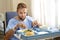 Man in hospital room eating healthy diet clinic food in upset moody face expression