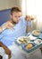 Man in hospital room eating healthy diet clinic food in upset moody face expression