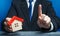 Man with a house makes a gesture of attention. Legal advice on terms a contract deal for purchase of real estate, lending