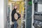 Man with a hub of utp cable works in the server room of the data center. The technician is near the racks with the servers. The