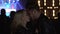 Man hugging and kissing girlfriend at night club, couple enjoying concert