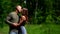 Man is hugging and kissing his slim beautiful girlfriend in park at summer day