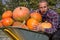 Man hugs big pumpkins,young man in autumn hugs orange pumpkins