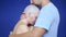 Man hugs a sad bald woman on a blue background. concept of oncology and the effects of chemotherapy.