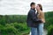 A man hugs a woman on top of a mountain