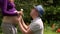 Man husband with hat bring daisy flowers and kiss belly of pregnant woman wife